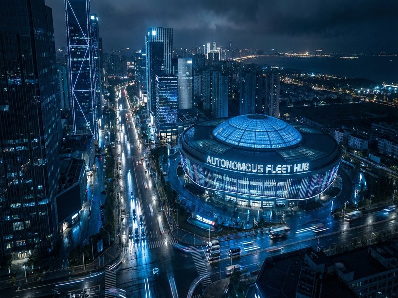 Aerial view of Autzu's autonomous hub coordinating vehicles across a city at night
